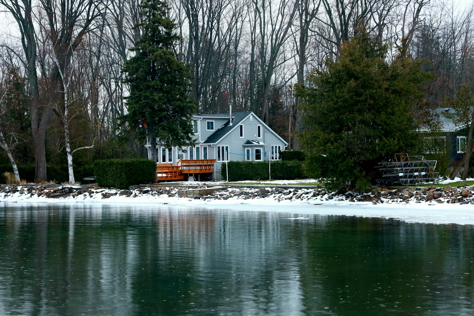 A light gray house by a body of water